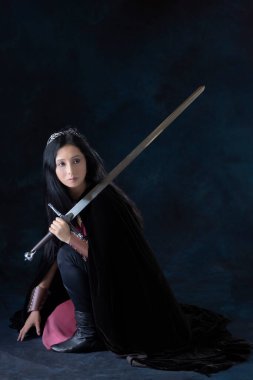 Bir elf (veya diğer fantezi karakteri) bağcıklı korse ve etek giyen ve kılıç tutan savaşçı bir kadın.