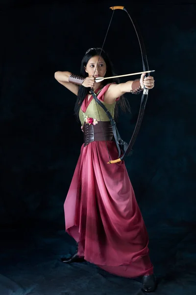 An elf (or other fantasy character) warrior woman wearing a laced bodice and draped skirt and holding a bow and arrow