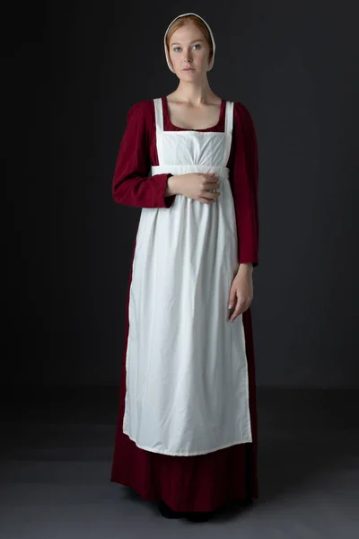 Egy Régenslány Szolgálólány Piros Vászonruhát Visel Kötényben Sapkában Egy Stúdió — Stock Fotó