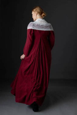 A Regency woman wearing a red linen dress with a white lace modesty shawl against a studio backdrop clipart