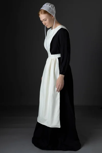 Een Amish Vrouw Met Een Zwarte Jurk Schort Pet Tegen — Stockfoto