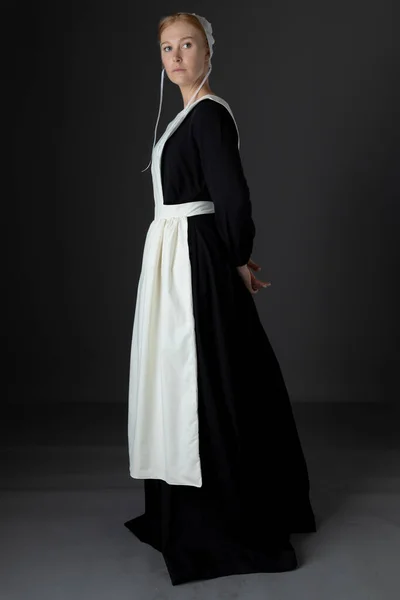 Een Amish Vrouw Met Een Zwarte Jurk Schort Pet Tegen — Stockfoto