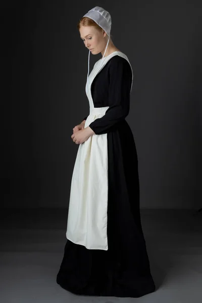 Uma Mulher Amish Usando Vestido Preto Avental Boné Contra Pano — Fotografia de Stock