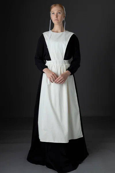 Uma Mulher Amish Usando Vestido Preto Avental Boné Contra Pano — Fotografia de Stock