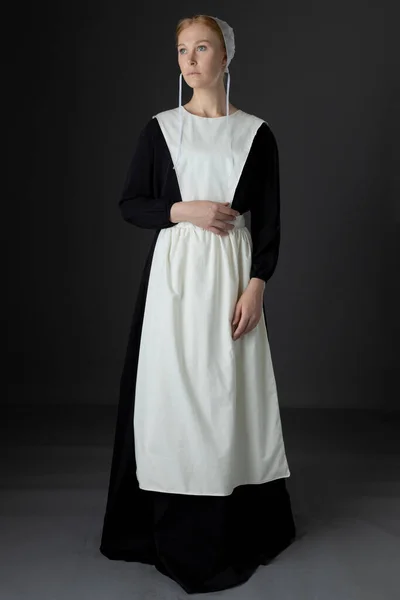 Amish Kvinna Bär Svart Klänning Förkläde Och Mössa Mot Studio — Stockfoto