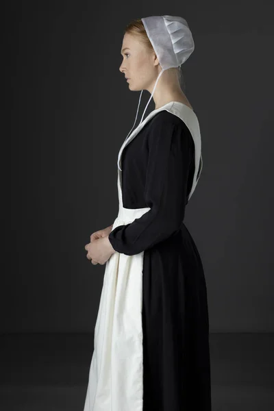 Uma Mulher Amish Usando Vestido Preto Avental Boné Contra Pano — Fotografia de Stock