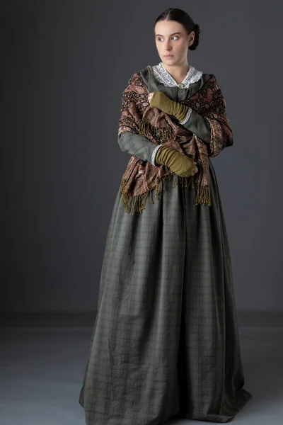 一位维多利亚时代的工人阶级妇女 穿着深绿色的紧身衣和一条长裙 头戴帕斯利围巾 — 图库照片