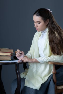 A Victorian or Edwardian woman sitting in a chair and reading a book