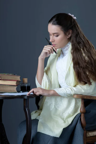 A Victorian or Edwardian woman sitting in a chair and reading a book