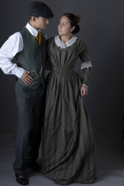 A romantic working class Victorian couple together against a grey studio backdrop