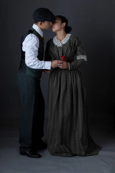A romantic working class Victorian couple together against a grey studio backdrop