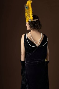 A 1920s woman wearing a party dress and a headband with a feather