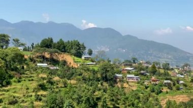Tepenin tepesindeki küçük bir köyün manzarası. Arka planda Himalaya Dağları var..