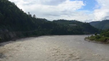 Nepal tepelerinin gölgesinde akan bir nehir..