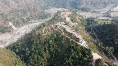 Nepal 'in engebeli tepelerinin insansız hava aracı manzarası. Tepesinde bir köy var..