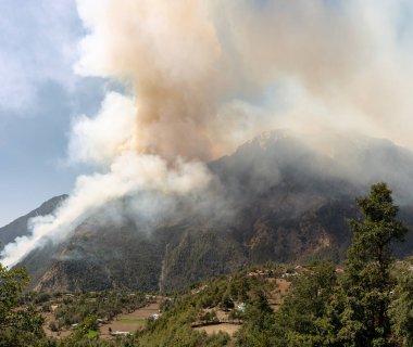 Nepal 'deki bir dağın üzerinden gökyüzünü kaplayan orman yangınının dumanı..