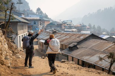 Phakding, Nepal - 10 Mart 2022: Himalaya Dağları 'ndaki küçük bir köy olan Phakding' deki Everest Ana Kampı 'na giden yolda bir hamal.