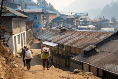 Phakding, Nepal - 10 Mart 2022: Himalaya Dağları 'ndaki küçük bir köy olan Phakding' deki Everest Ana Kampı 'na giden yolda bir hamal.