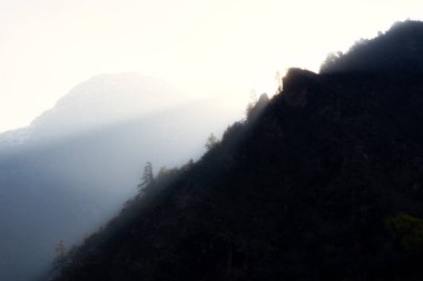 Parlak sabah güneşi bir dağın sırtından süzülüyor ve ışınlarını vadiye yolluyor..