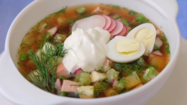 Kvass ve sosisli Okroshka. Geleneksel soğuk Rus çorbası. Yakın çekim, döndürme.
