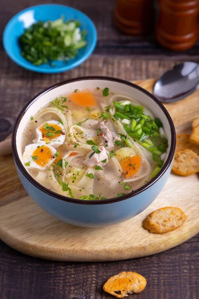 Tavuk, erişte, patates, bıldırcın yumurtası ve havuçlu çorba. Soğan ve maydanozla tatlandırılmış. Yakın plan..