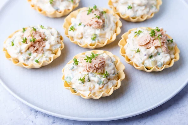 Morina ciğeri, morina balığı havyarı, salatalık ve mikroyeşillikle doldurulmuş turtalar. Geleneksel soğuk porsiyonlu aperatif bir pasta sepetinde. Yakın çekim, üst görünüm.