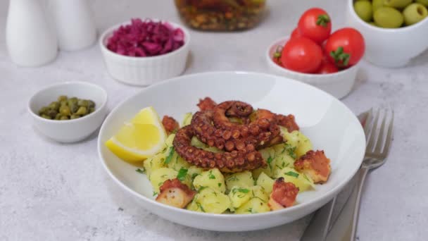 ジャガイモ トマト 赤キャベツ オリーブ ケッパー レモンと暖かいサラダ白いプレートに 伝統的なギリシャ料理 クローズアップ 白の背景 ズームイン — ストック動画