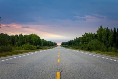 Dramatik gökyüzü ile uzak, uzun ve boş bir yol