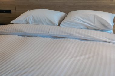 Beyaz yatak yastıkları ve yatak odasındaki yatak örtüleri.