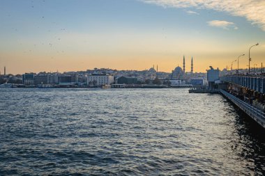 İstanbul Boğazı Boğazı, gün batımında Galata Köprüsü 'nde seyir ve feribot manzaralı. Galata Köprüsü 'nün ünlü simgesiyle İstanbul şehri