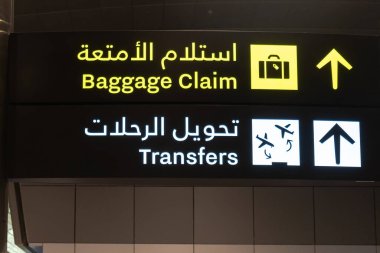 İngilizce ve Arapça olarak yazılmış havaalanı aktarım işareti ve bagaj teslim belgesi.