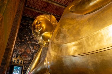 Bangkok, Tayland 'da ünlü bir Budist tapınağı kompleksi olan Wat Pho' da uzanan Buda heykeli.