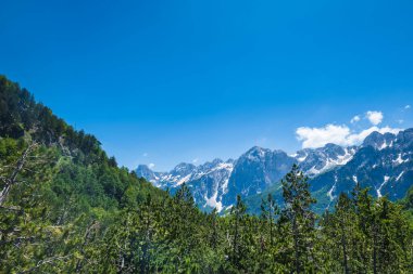 Arnavutluk Alpleri manzaralı. Arnavutluk 'ta Valbona ve Theth yürüyüş parkurlarından görülen lanetli dağlar, Arnavutluk Alplerinde popüler yürüyüş parkurları.