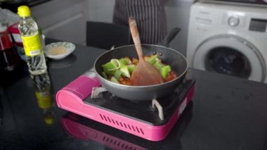 Ev hanımı evdeki tavada ev yapımı kızarmış Kore Kochujang domuz eti pişiriyor..