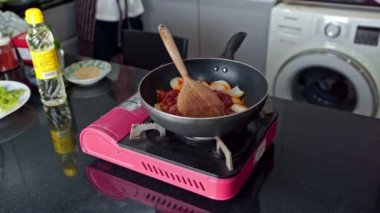 Kore kimchi 'si pişiriyorum. Kızarmış kochujan domuz etini evde sıcak bir tavada karıştırıyorum..