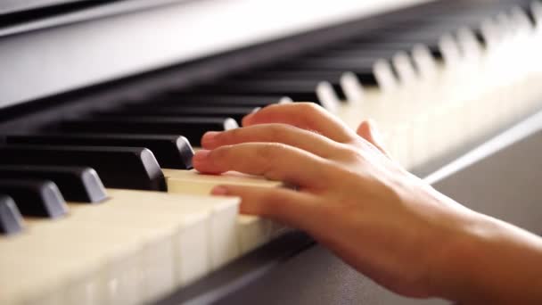 小さな手と指の小さな女の子あります演奏上のピアノキーでスローモーション — ストック動画