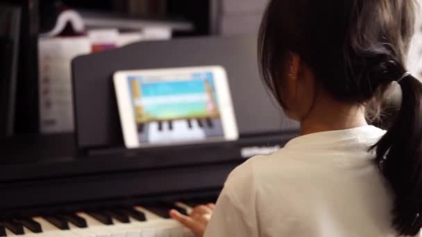 Chica Asiática Está Aprendiendo Practicando Música Piano Usando Tableta Línea — Vídeo de stock