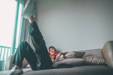 Asyalı spor mankeni kız havalı bir sokak sporu modası için beyaz spor ayakkabıları ile bir apartmanda poz veriyor.