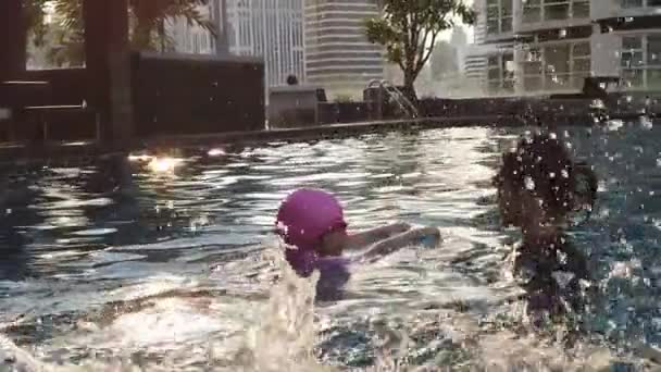 亚洲母亲正在教和训练她的女儿在公寓游泳池里游泳 — 图库视频影像
