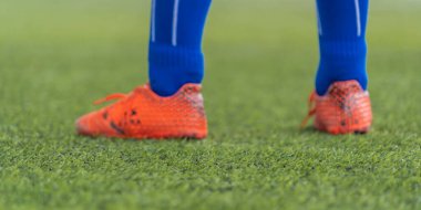 Çocuk futbolcu ayakları gençlik futbol antrenmanı konsepti için yeşil çimlere kapanmış..