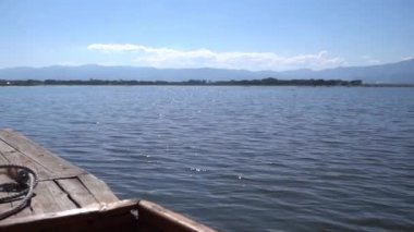 Küçük ahşap tekne açık bir gölde seyahat ediyor..