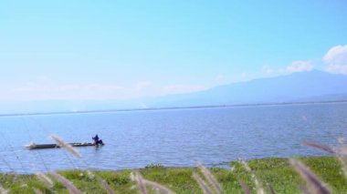 Tayland, Phayao 'da sakin bir gölde küçük bir balıkçı teknesi yüzüyor..