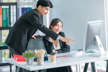 Üst düzey erkek memur, kadın işçilere bilgisayar işlerinde yardım ediyor, takım çalışması konsepti için..