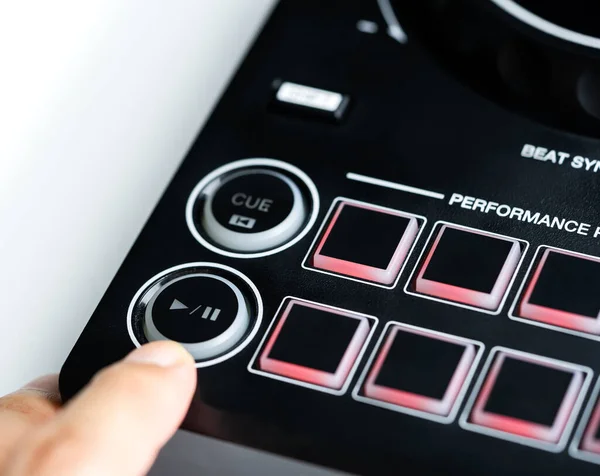 Digital DJ mixing deck Controller closed up on the Play Pause button.