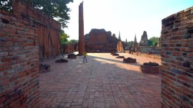 Turist kız, Tayland 'ın Ayutthaya eyaletinin eski harabelerinde geziyor..