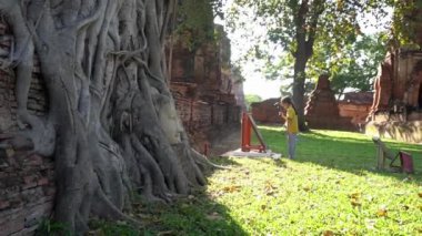 Küçük kız, Ayutthaya, Tayland 'ın antik harabelerinde tarih araştırıyor ve kendini eğitiyor..