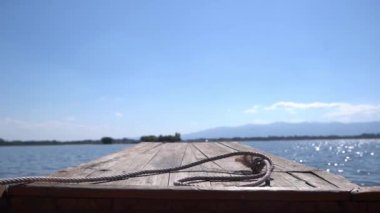 Tahta gemi başı durgun bir gölde ağır çekimde yüzüyor.