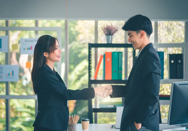 亚洲男性和女性商人在办公室里愉快地握手 — 图库照片