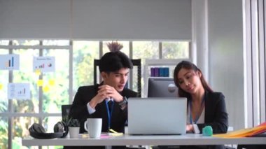 Business couple is discussing work in laptop computer in an office.