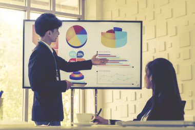 İş adamı bir konferans odasında televizyon ekranında iş ve akış şemasını sunuyor..